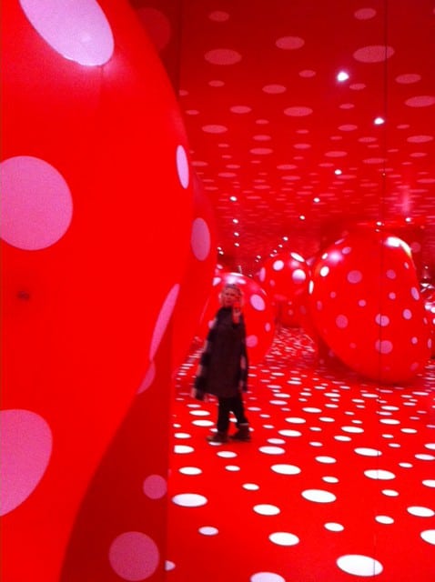 en tilskuer i en installation med røde prikker 